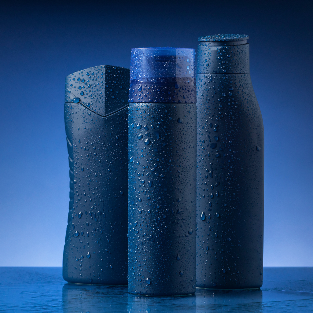 Three sleek HydraMark water bottles with condensation, standing against a cool blue background.