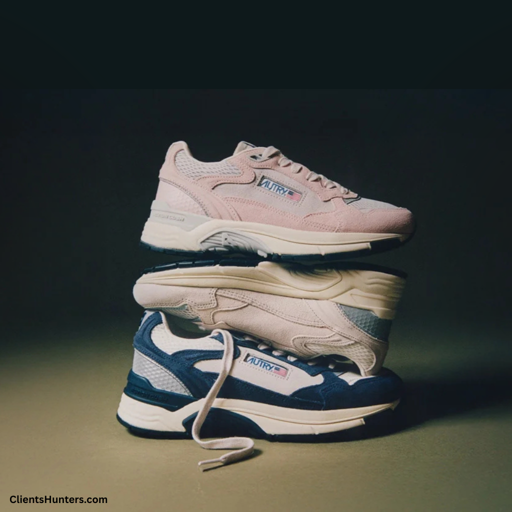 Three stacked Autry Windspin sneakers in pastel pink, beige, and navy blue colorways, showcasing retro design with modern textures and chunky soles.