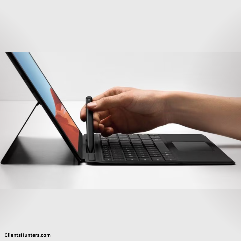 Hand placing Slim Pen 2 into Microsoft Signature Keyboard's storage slot on a Surface Pro device.