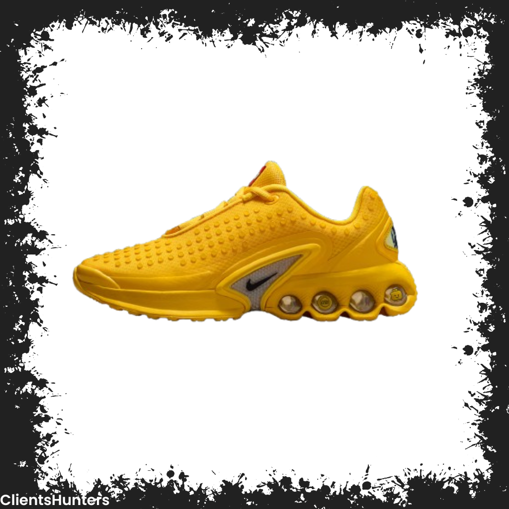 Bright yellow Nike Air Max DN x LEGO sneaker with LEGO-style studs and mini-figure details.